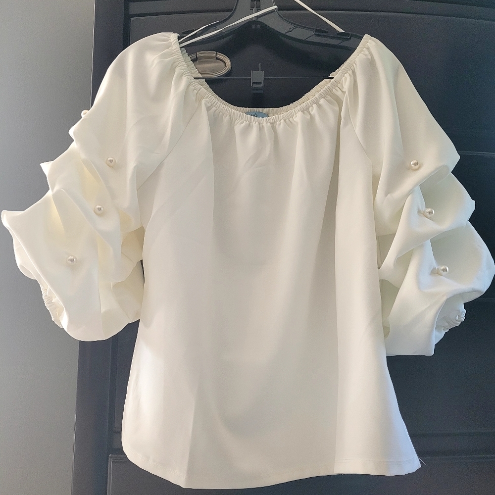 Beautiful blouse with accent pearls on sleeves.